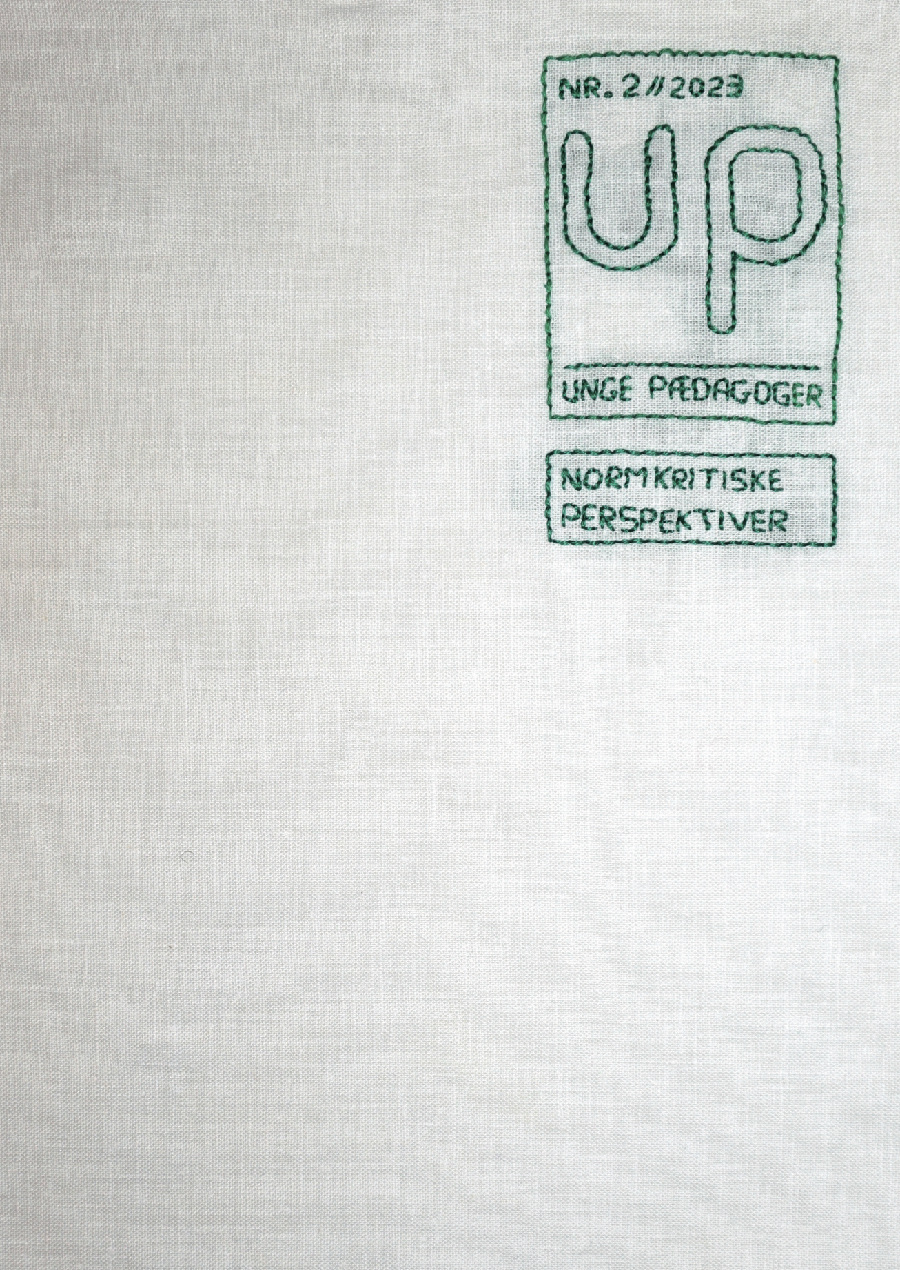 Forside udarbejdet i broderet stof. Jævn melfarvet kun med Unge Pædagogers log og titlen "Normkritiske perspektiver".